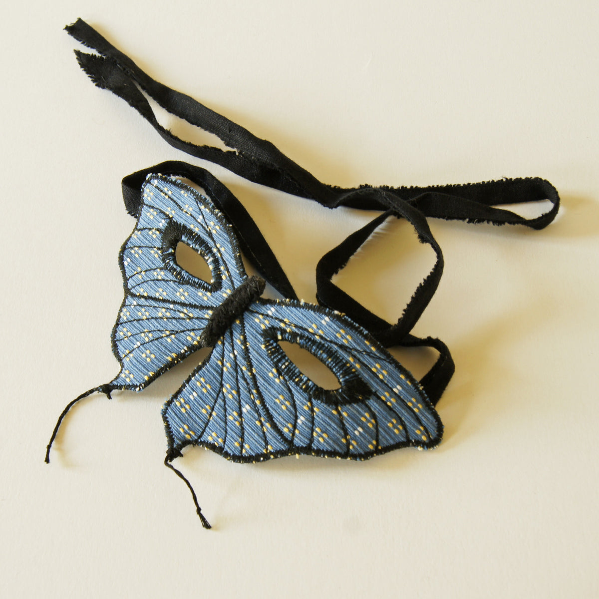 Tailed butterfly mask in blue upholstery fabric