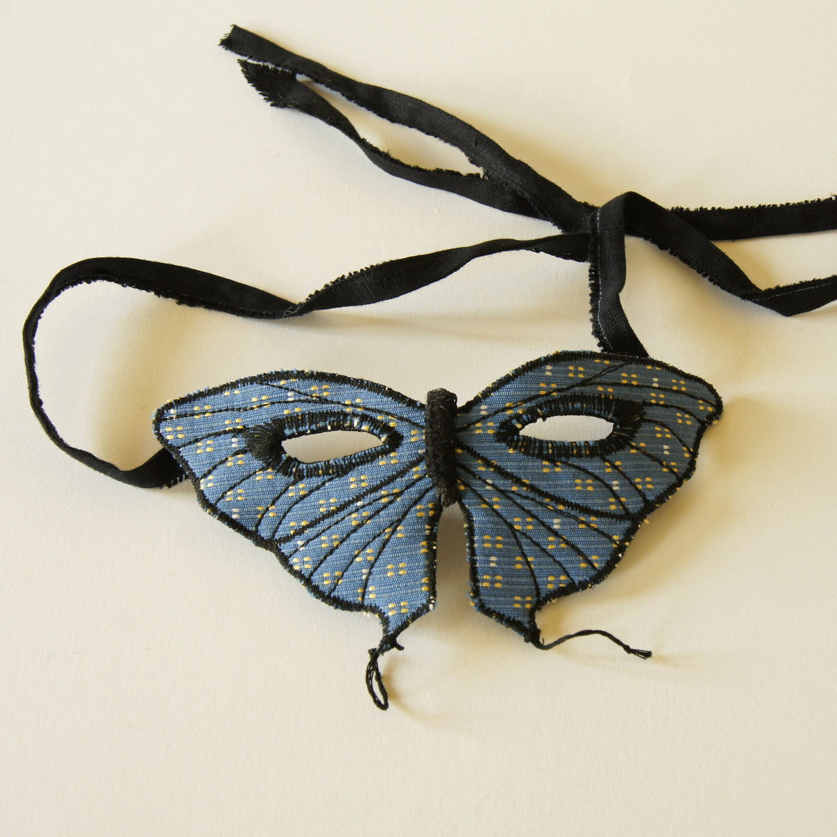 Tailed butterfly mask in blue upholstery fabric
