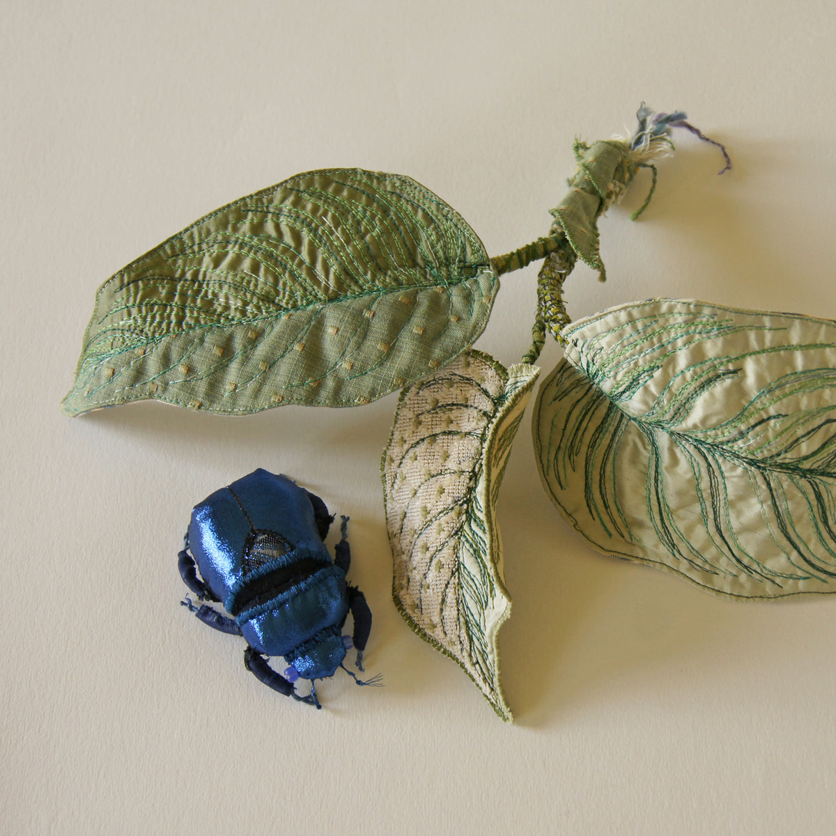 Blue jewel scarab and philodendron leaves textile sculpture