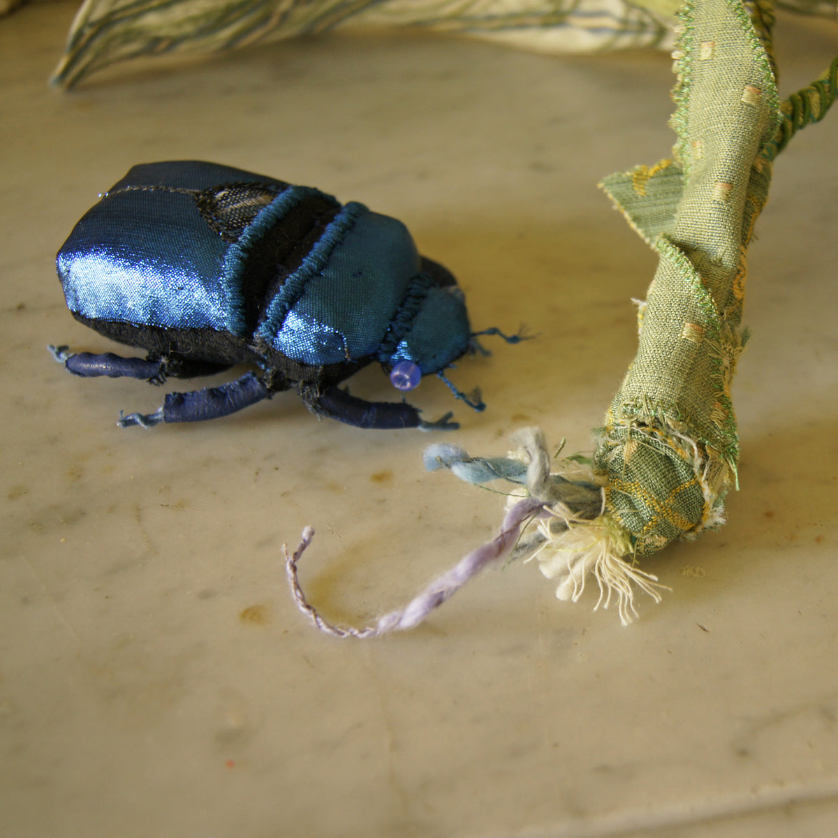 Blue jewel scarab and philodendron leaves textile sculpture